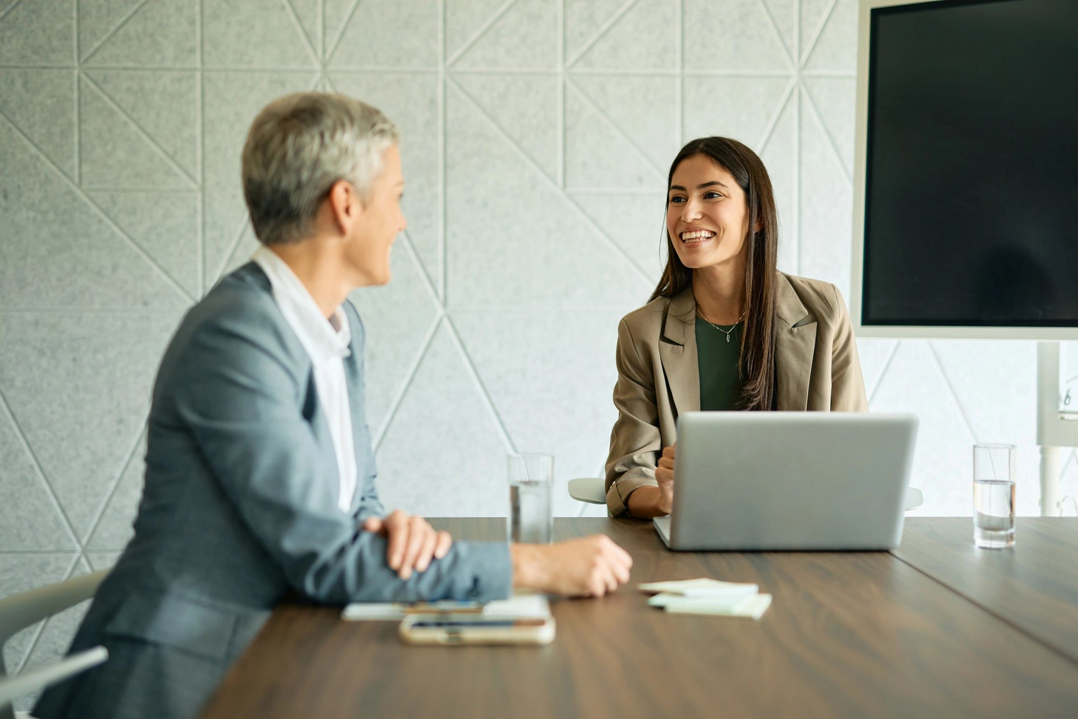 HR consultants collaborating at a laptop in a modern office